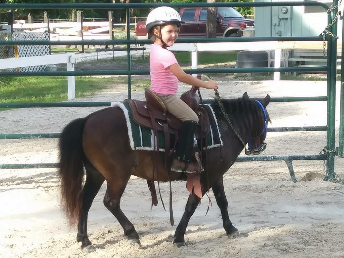 Audrey riding Elvis, her first pony, in the round pen