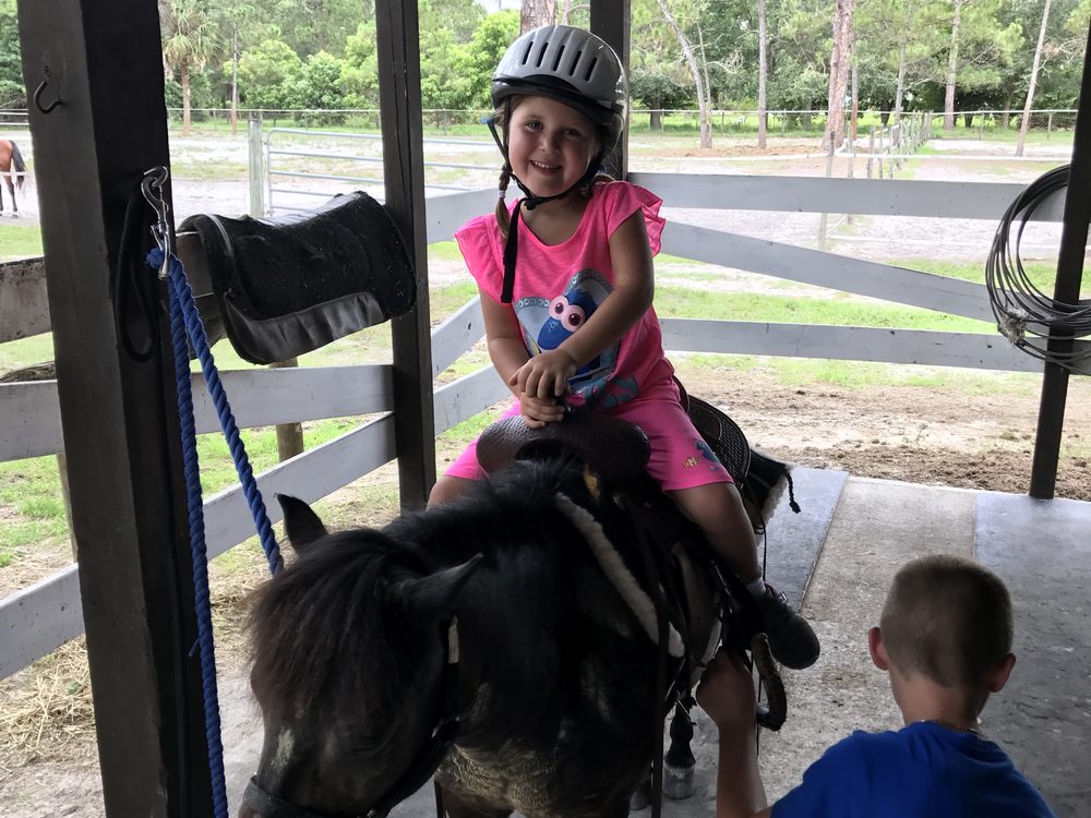 Audrey in a riding helmet sitting on Elvis